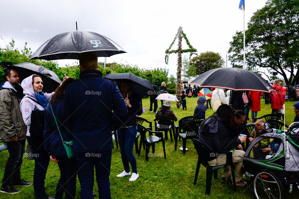 Swedish people is celebrating midsummer in the rain.