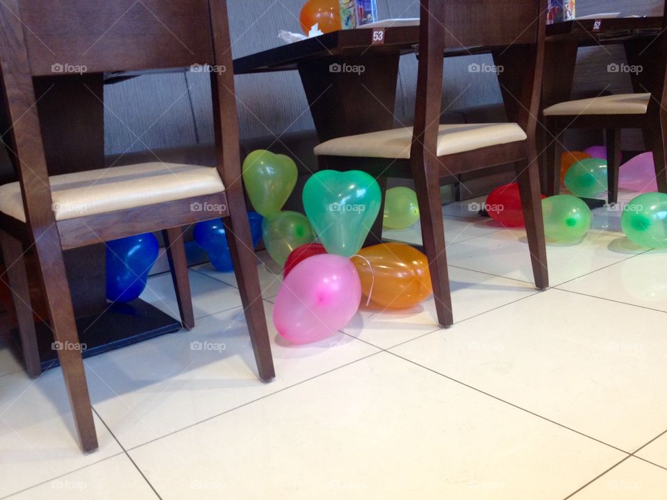 Balloons on the floor and under tables of a restaurant  