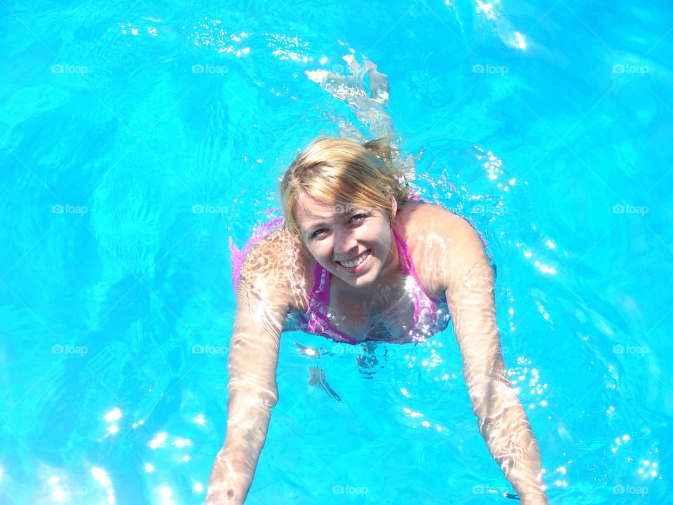 Portrait of a young woman in blue swimming pool