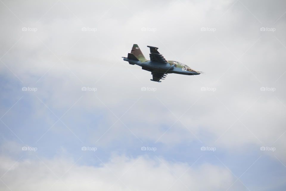 The plane is flying against the blue sky. Aerobatic figure, military aircraft.