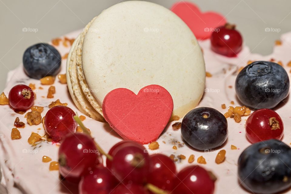 Delicious cake with fruits, sugar hearts and macaroni