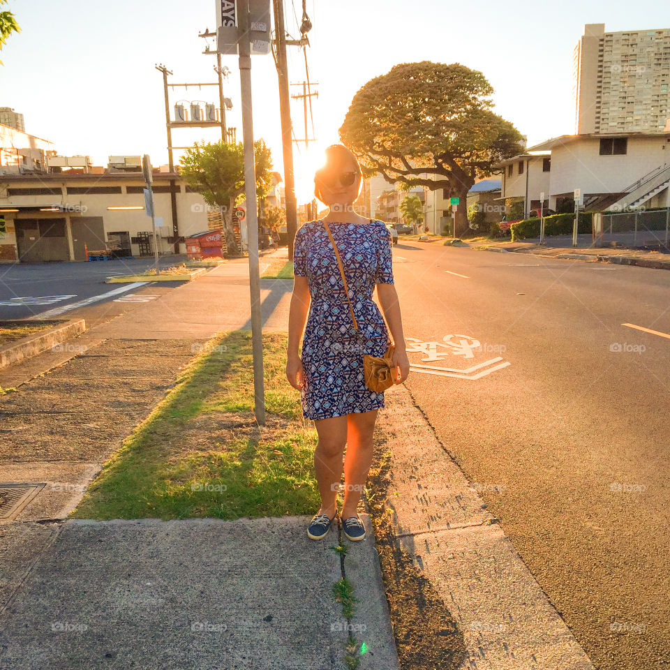 Magic hour women. A girl standing at the street against the sun
