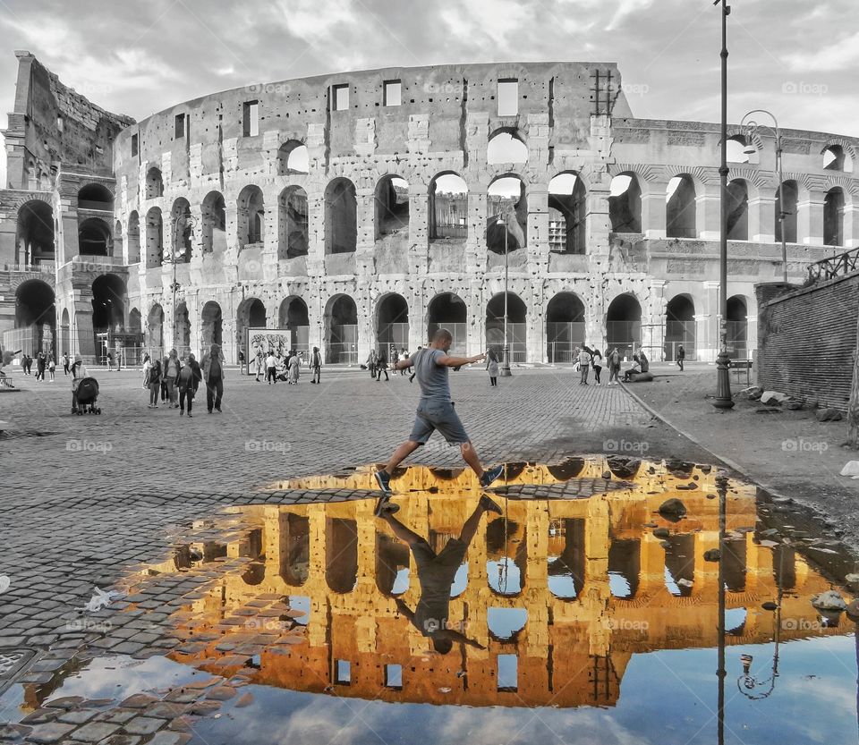 Walking over the Colisseum puddle reflection in a black and white background. Rome Italy
