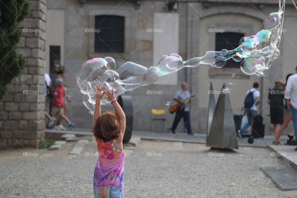 Girl catching bubbles in Barcelona 