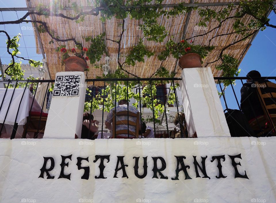 Vines clambering above a restaurant outdoor patio area 