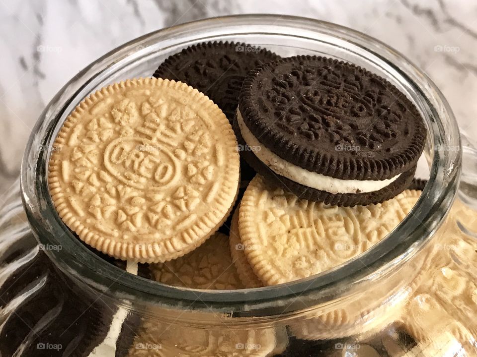 Golden and chocolate double stuff Oreo cookies and a cookie jar