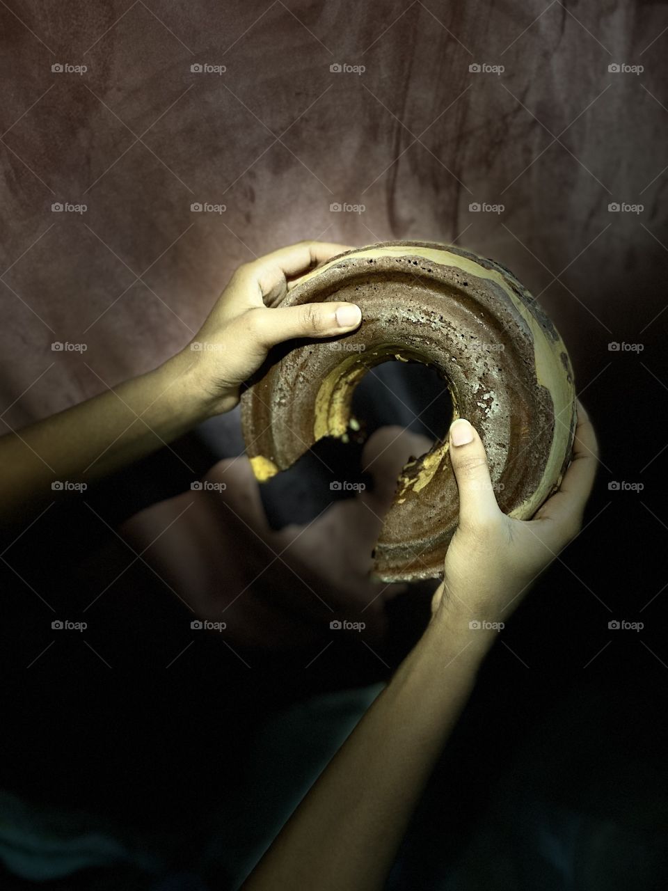 My sister holds the cake in her two hands and wants me to take a picture of it
