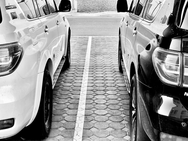 Black and white photography, suv cars black and white colors parked nearby 
