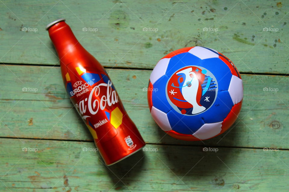 miniature soccer ball and coca cola bottle on a wooden table