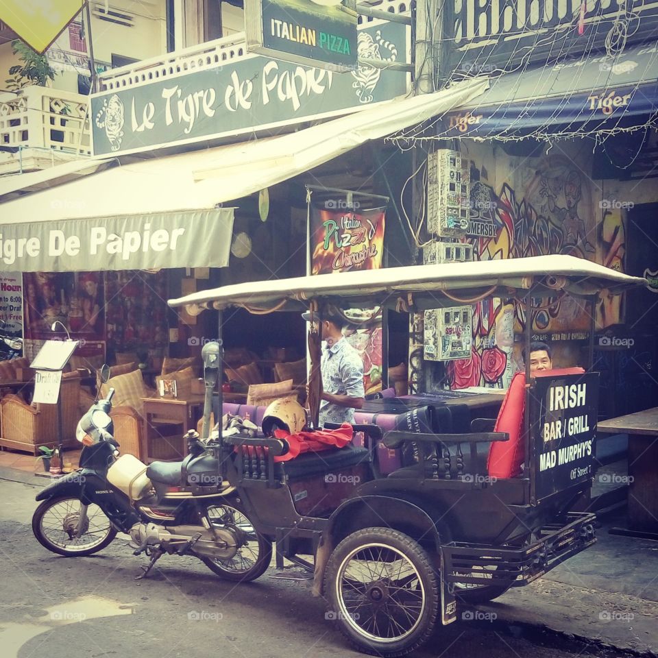 A taxi bike in the city centre of Siem Reap. A retro style of a transportation visible in any public places in Cambodia.