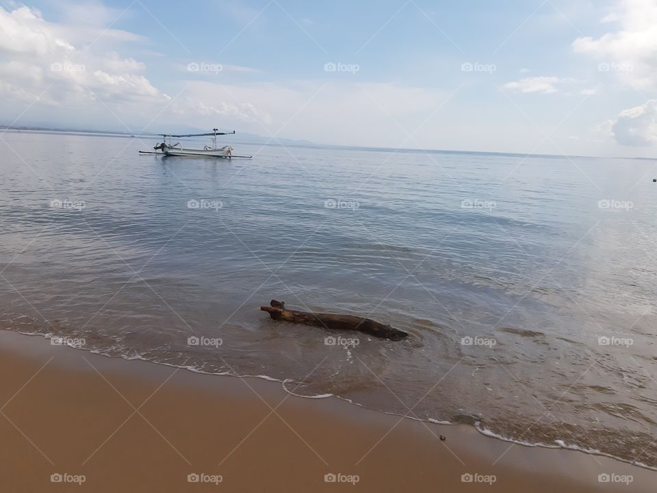 A floating trunk and a boat under the morning sky