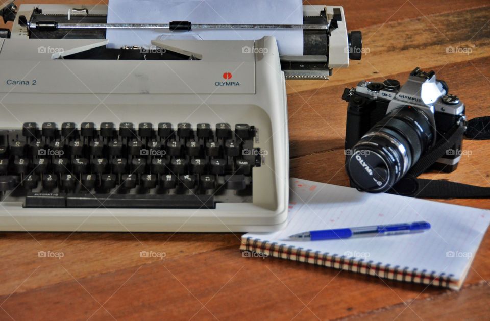 Typewriter,camera and note book on the wooden table