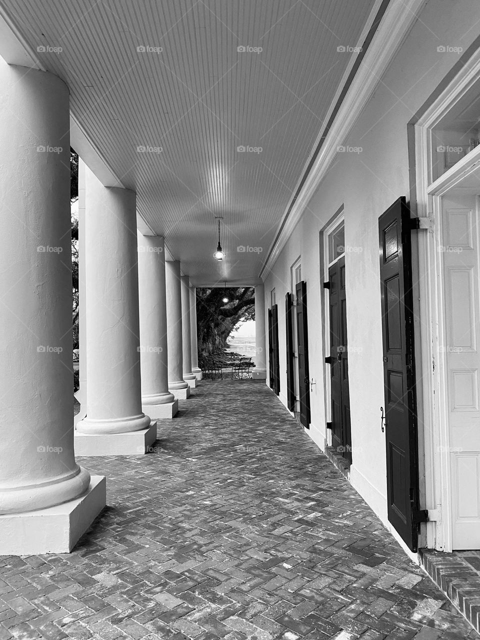 An outdoor walkway with columns on one side and doors on the other
