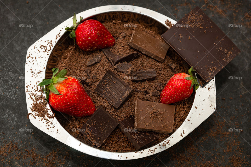 three strawberries in a bowl of chocolate