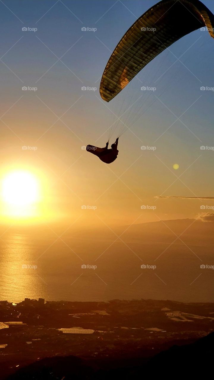 sunset with paraglider high in the air