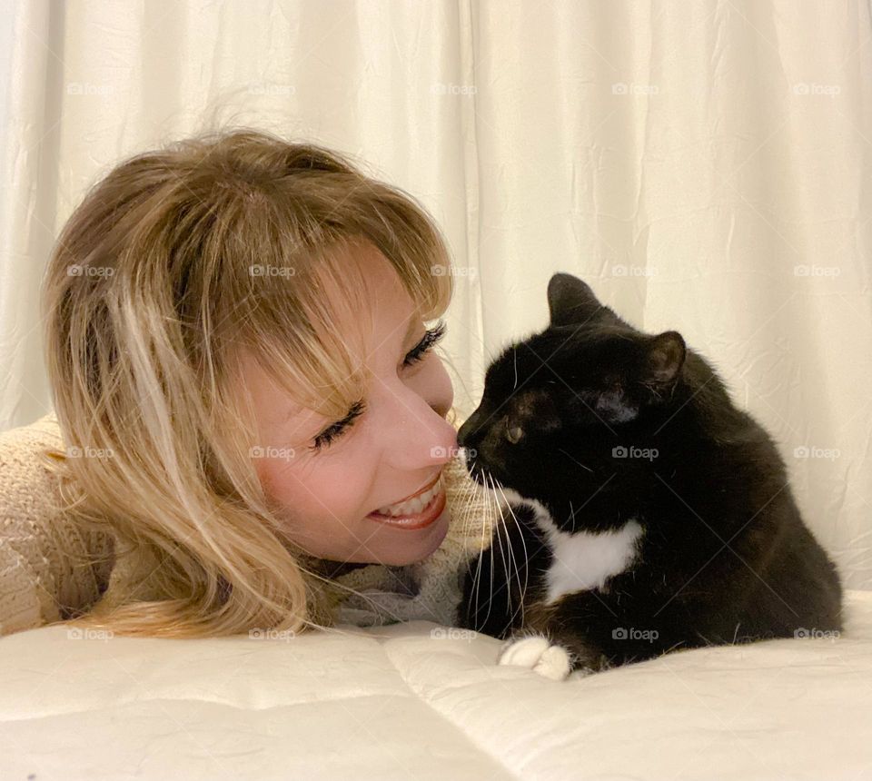 Selfie of a woman touching noses with her cat 