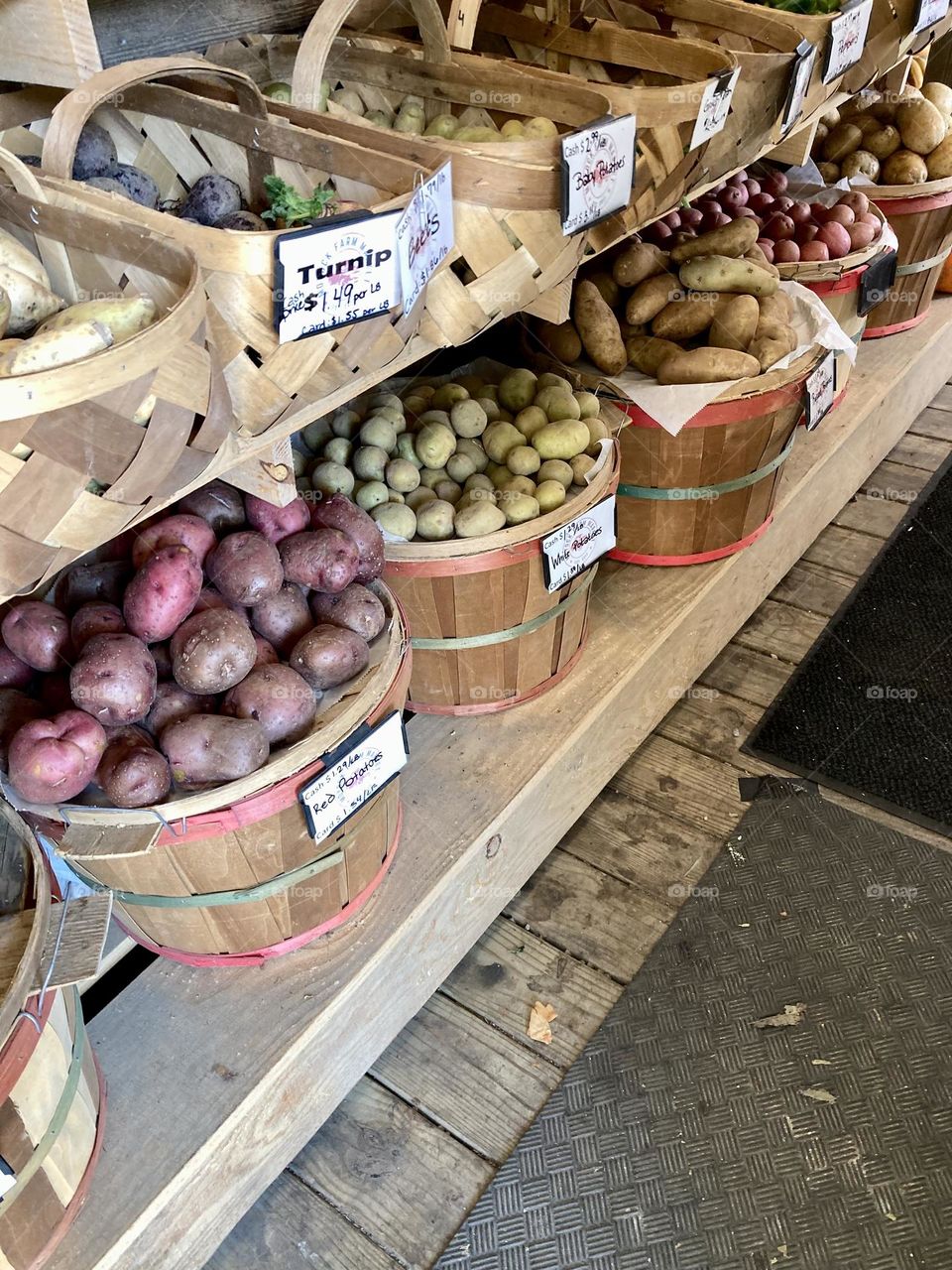 Vegetables in baskets at farmers market on shelves 