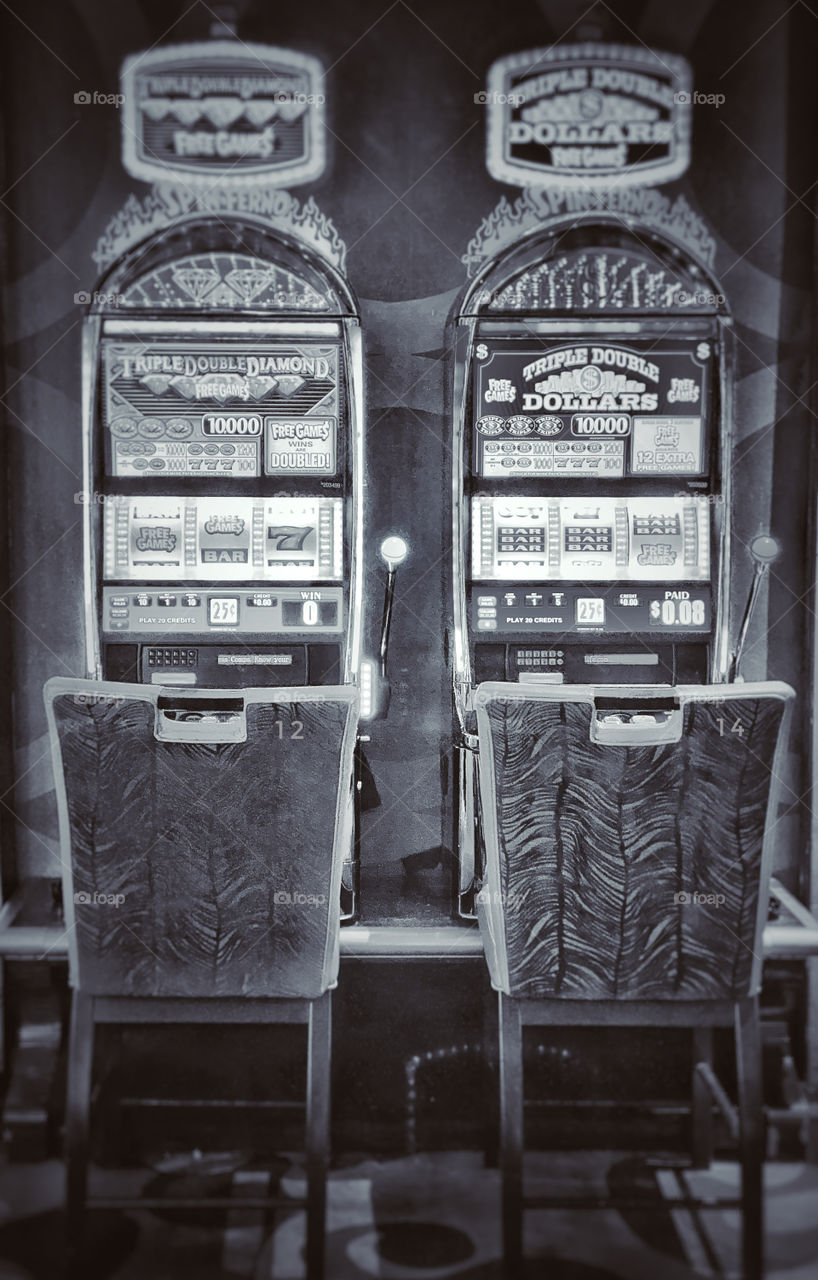 Two empty chairs in front of slot machines numbered 12 and 14