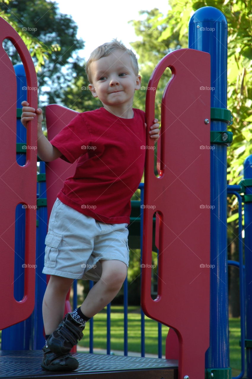 Playground Pose. Boy playing on the playground of downtown City park