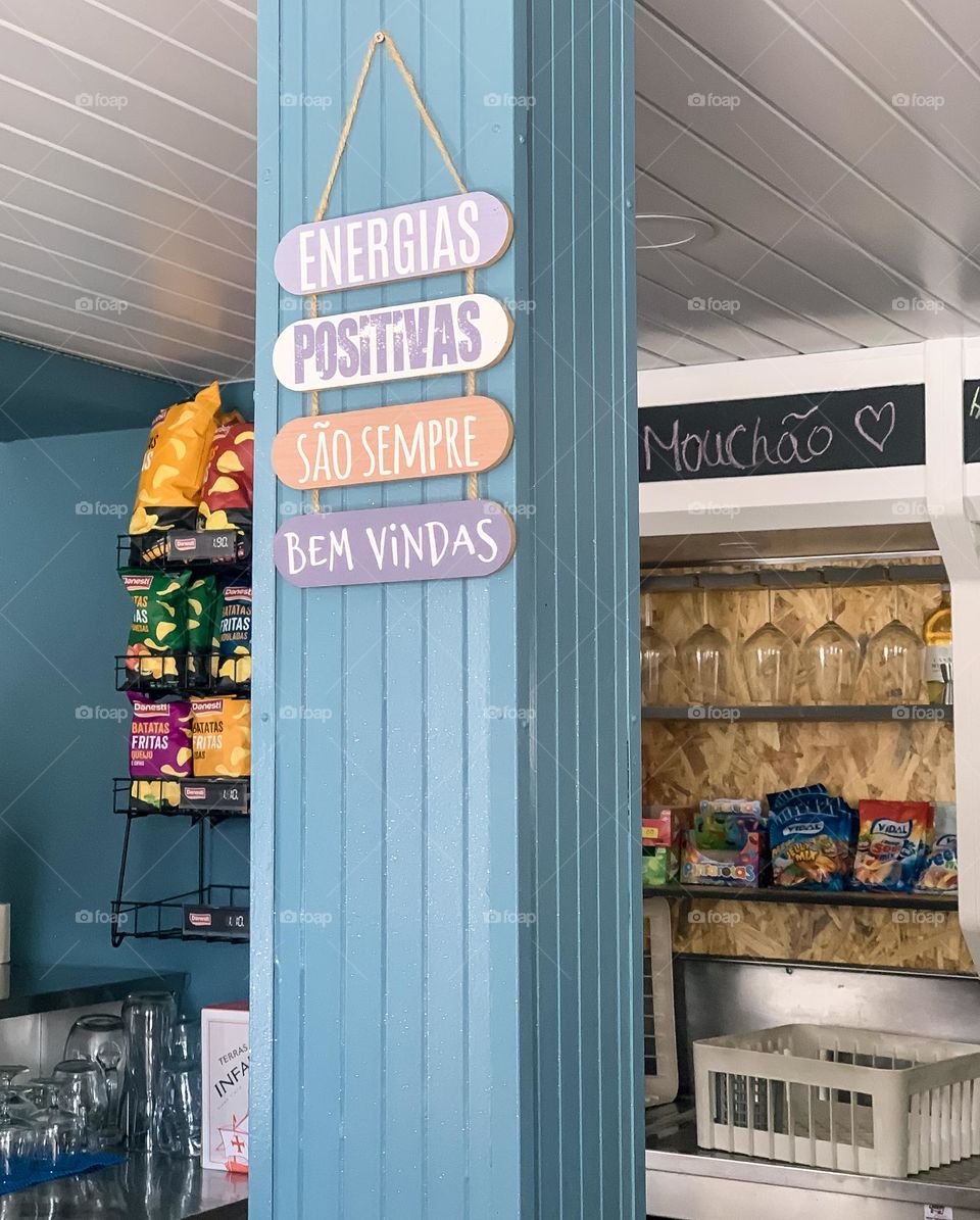 Welcoming signs on a blue pillar in a cafe