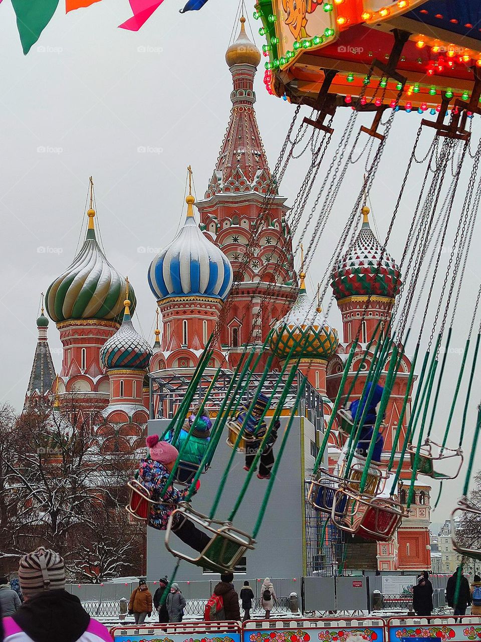 life in motion.  People ride the carousel.  In the background is the Cathedral of St. Basil the Blessed on Red Square.