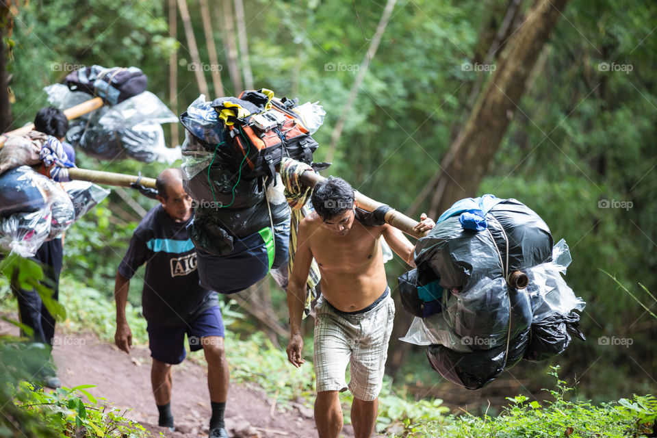 Man carrying a lot of bag in their shoulder in Phu Kradueng national park Loei Thailand 