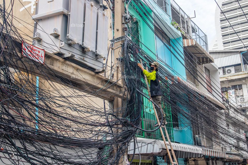 man at work, electrician in the streets of the Metropolis Bangkok Thailand Southeast Asia