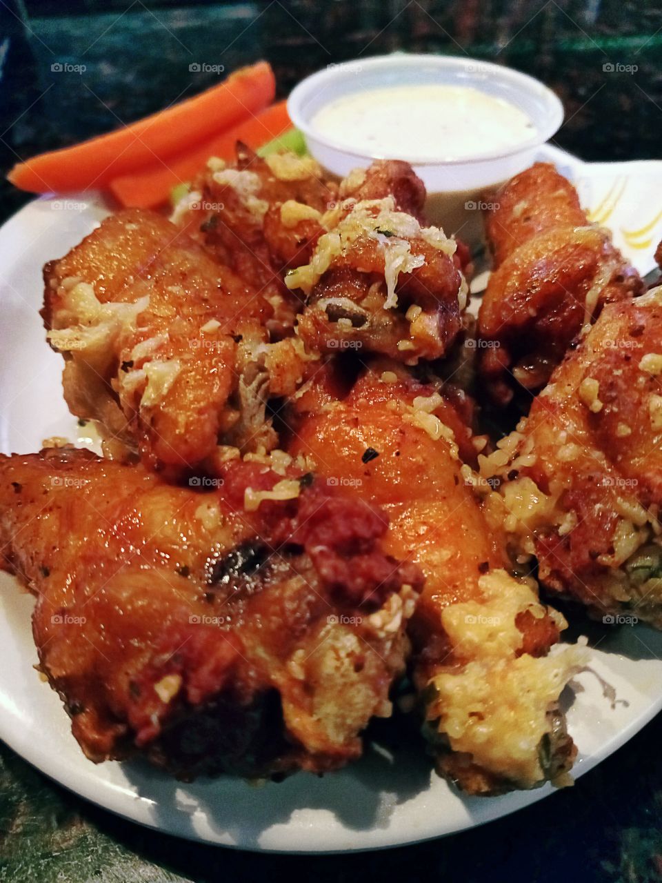garlic chicken parmesan wings with ranch dressing on the side.