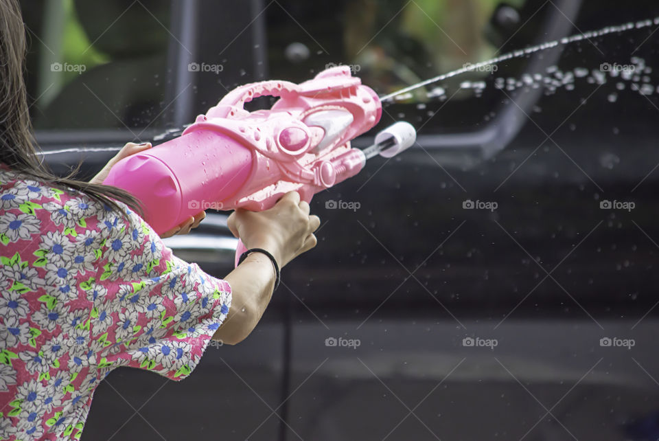 Hand holding a water gun play Songkran festival or Thai new year in Thailand.