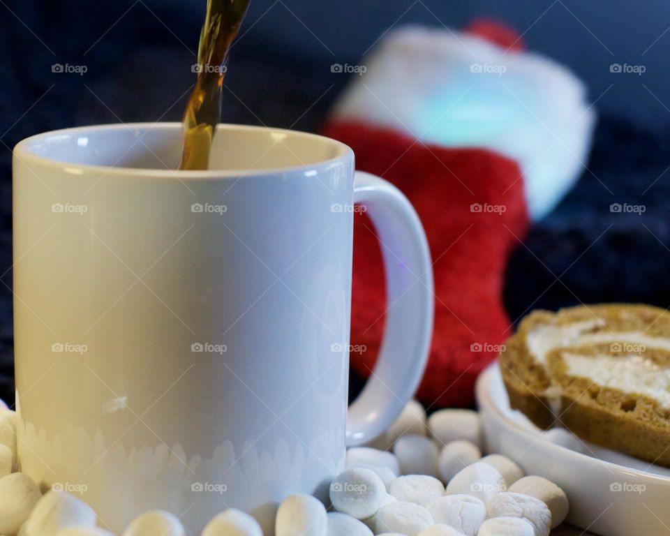 Fresh cup of coffee with marshmallows and a pumpkin roll; Holiday setting