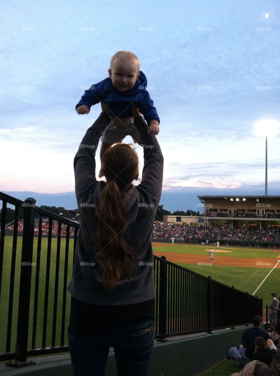 Playing with mommy at his first baseball game