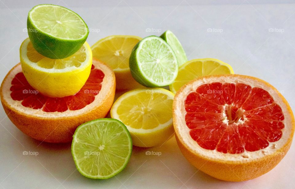 Still life of of grapefruit, lime and lemon halves on white background