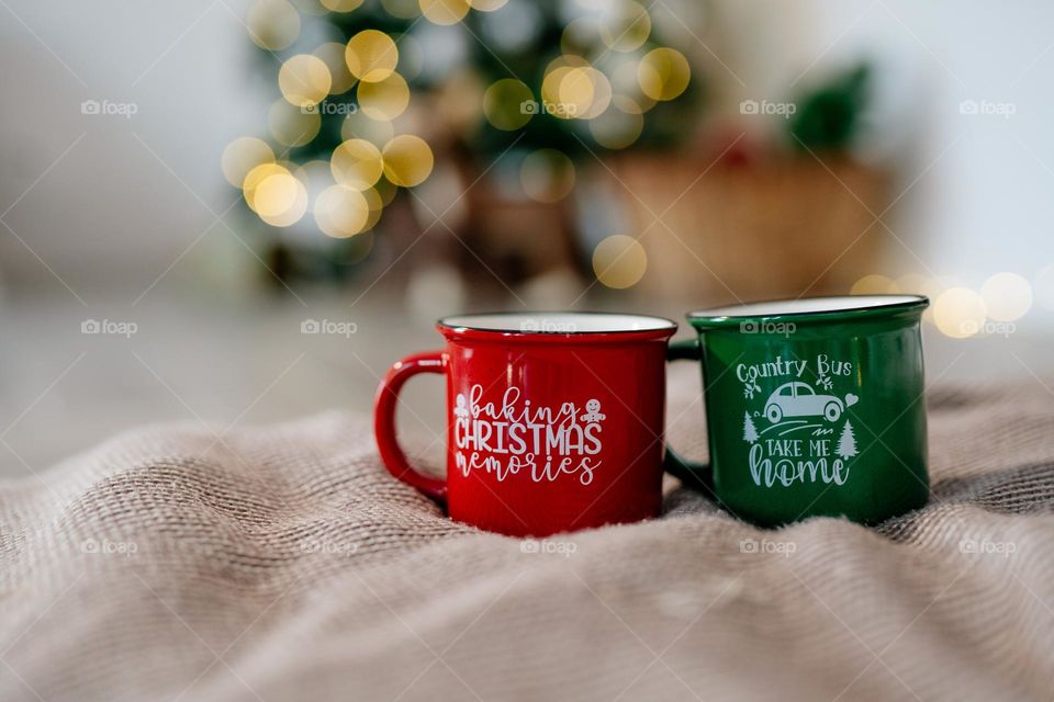 Two Christmas mugs with festive prints. Holiday mood. Hot beverages