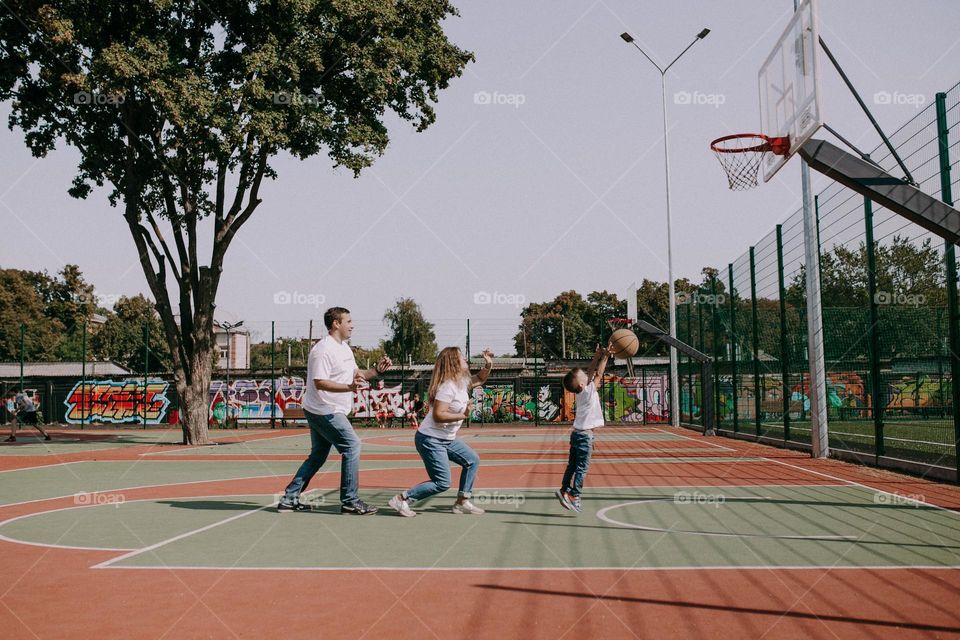 Family play basketball outside