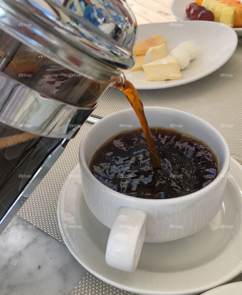 Pouring a cup of coffee in the morning to get the day started.  Rich, brown color poured from a French press 