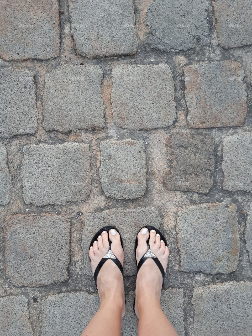 Woman's feet on the old sidewalk