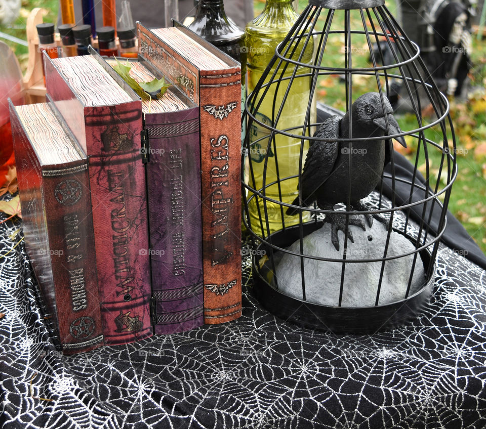 Crow in a cage and books on the occult