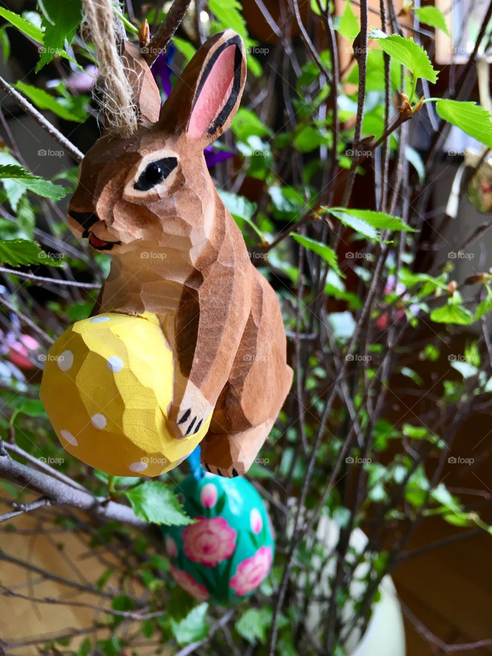 Easter bunny in tree with yellow egg. 