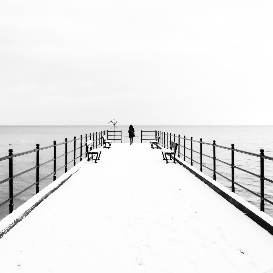 Rear view of a woman standing on pier