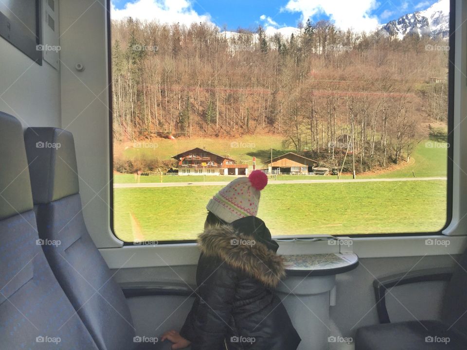 Girl sitting in train looking outside nature