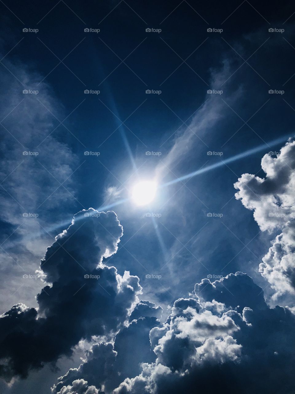 Majestic view of some cloud formations, lens flare with shadows and dramatic highlights.