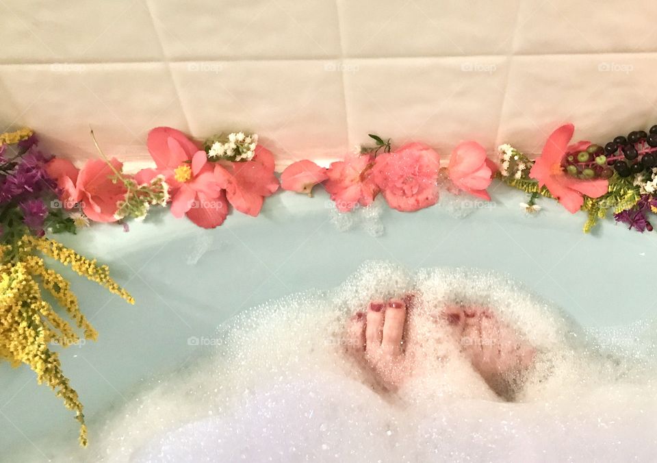 Relaxing in a bubble bath with fragrant flowers