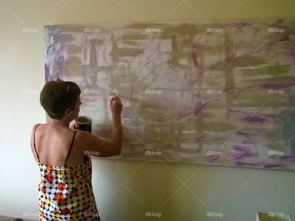 A photograph of my mother painting a large canvas for the living room in her new property. 
