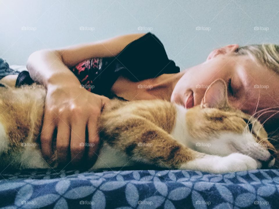 woman and her cat sleeping in bed
