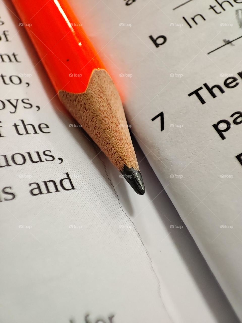 A simple photo an orange pencil in a notebook, macro photo of a pencil, closeup of the wooden pencil