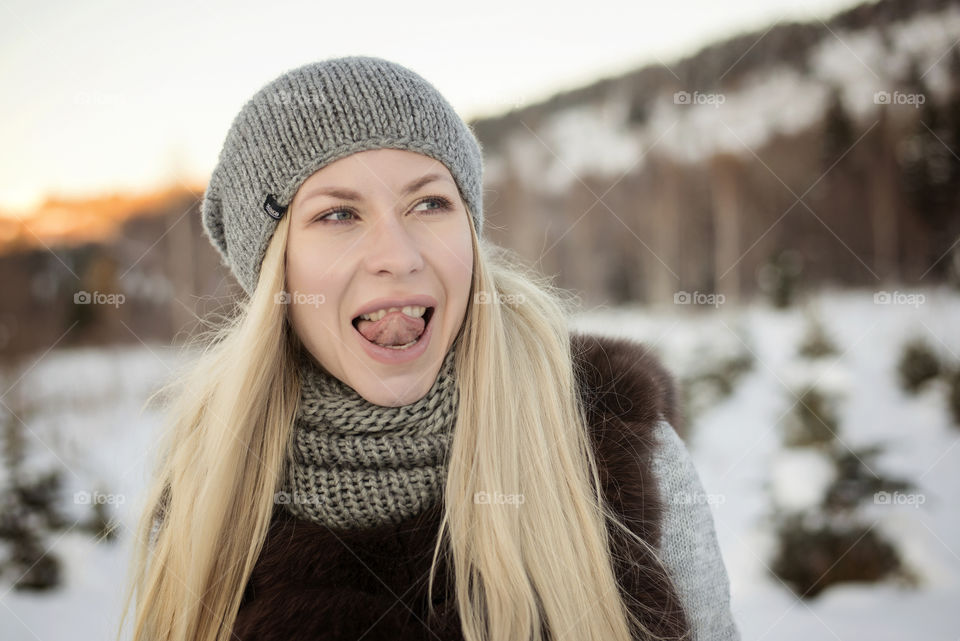Portrait of young woman sticking out tongue