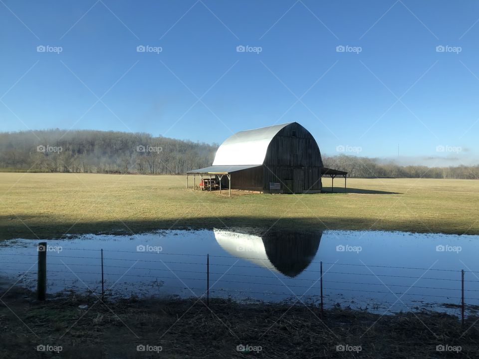 A beautiful old barn stands proud in the morning light of a sweeping Arkansas countryside