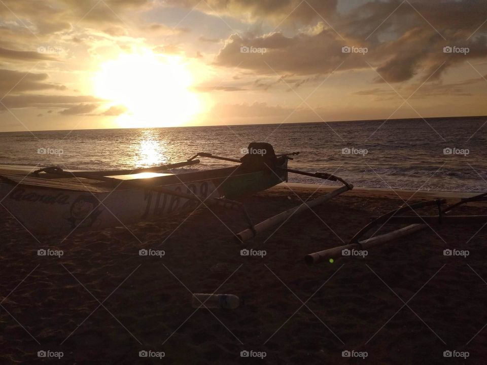 a boat at the beach during sunset