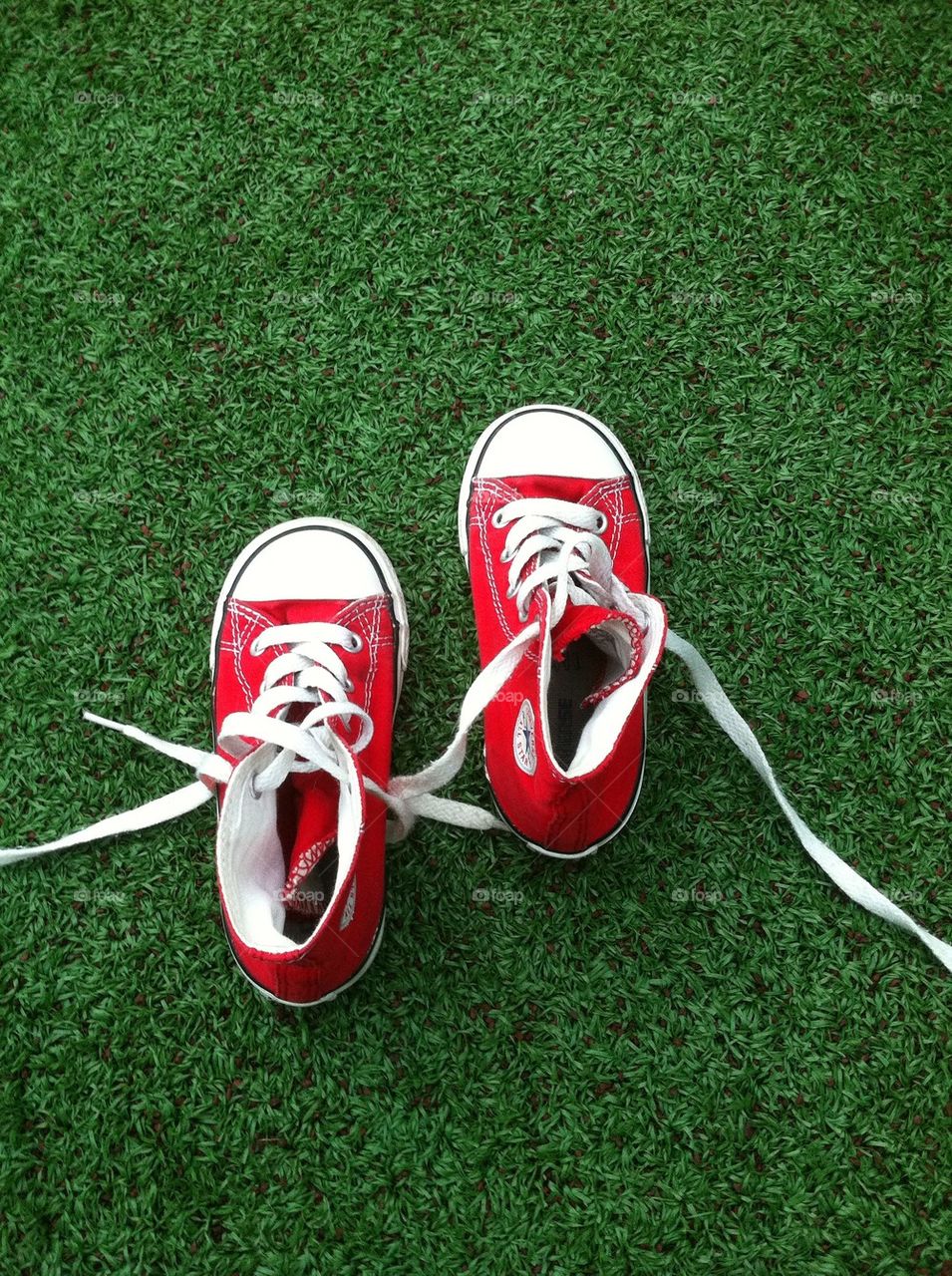 Baby red shoes with green background