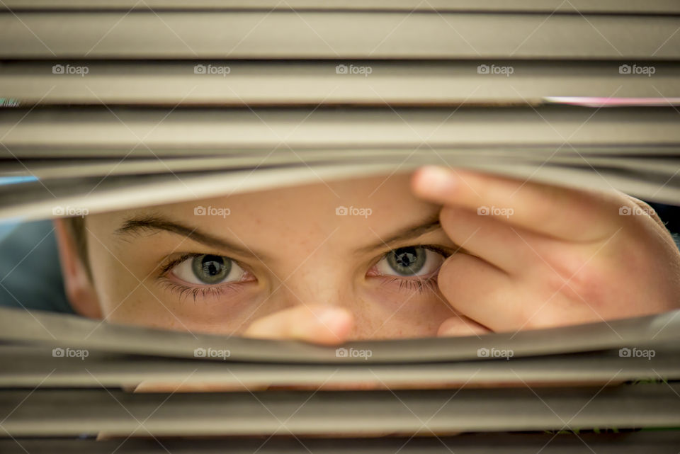 little boy peeping through the blinds